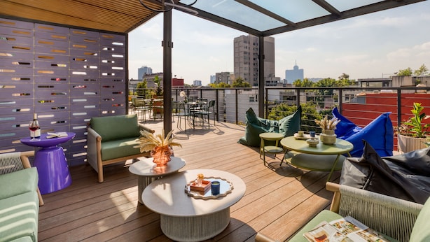 A rooftop terrace with outdoor seating, a pergola, and a city view. - ULIV Condesa (Mexico City)