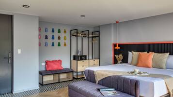 Quarto moderno com uma cama grande, um banco, uma cômoda e um cabideiro fixado na parede.