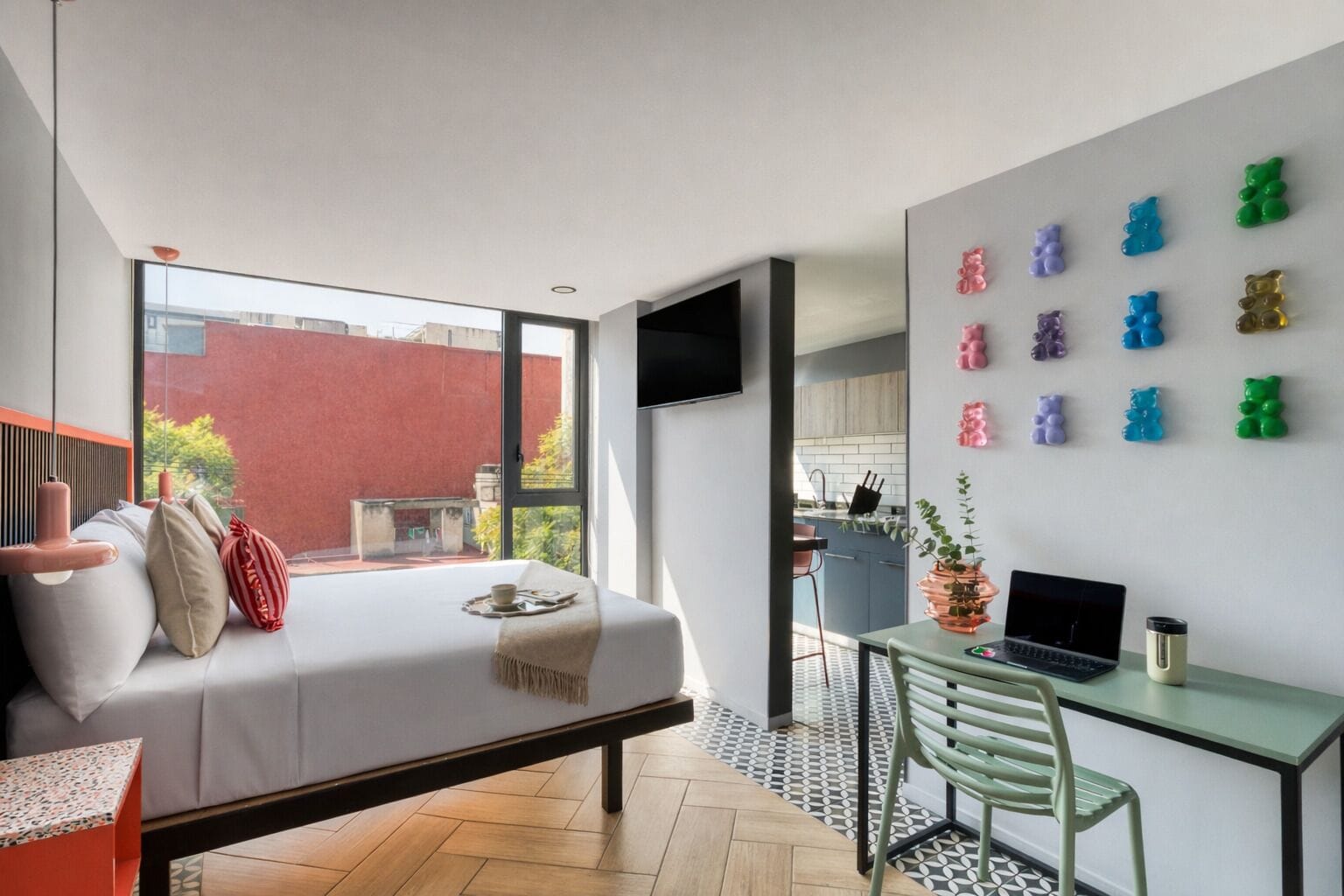 A modern bedroom with a bed, a desk, and a TV.