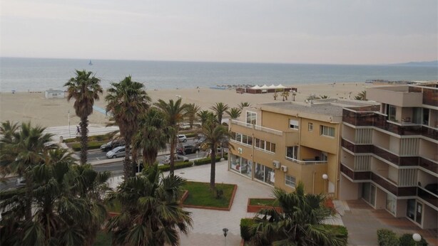 A coastal hotel with a beach view, multiple floors, and a parking area with cars. - Bright 2-room apartment with private parking at Canet-Plage (Canet-Plage)