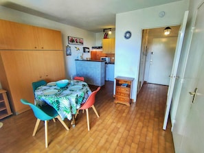 A compact living space with a dining area, kitchenette, and a small wooden cabinet. - Studio Cabin Sleeps 4 at Canet-Plage with Parking, Near Beach and Shops (Canet-Plage)