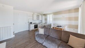 Un appartement moderne comprenant un coin cuisine, un espace repas et un salon avec un canapé.