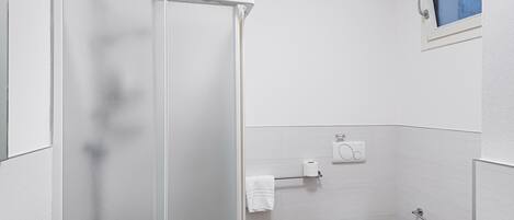 Ein Badezimmer mit Dusche, Toilette und Badewanne.