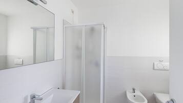 Een douche, een haardroger, een bidet, handdoeken