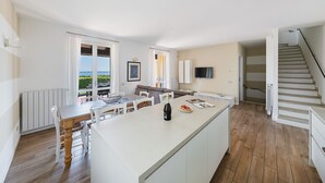 Une cuisine spacieuse dotée d’un îlot central, d’un coin repas et offrant une vue sur l’extérieur.