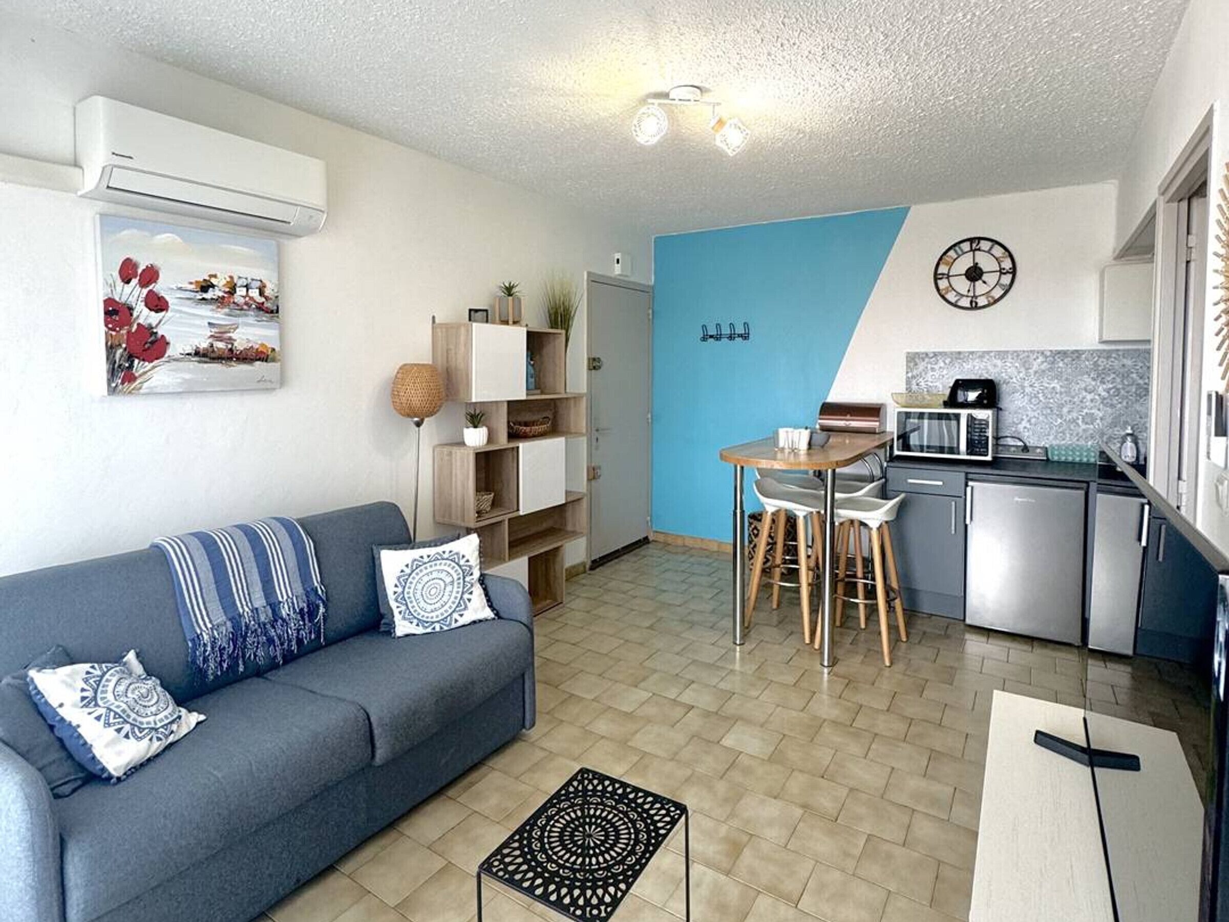 Een knus woongedeelte met een bank, een eettafel en een kitchenette.