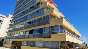 Un hotel de varios pisos con balcones, ventanas amplias y techo plano.