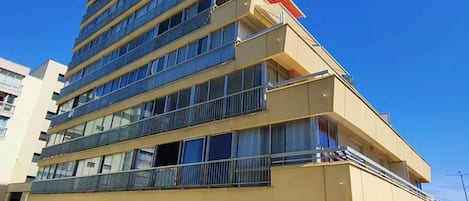 Een hotel met meerdere verdiepingen, balkons, grote ramen en een plat dak.