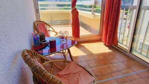 Un balcón con mesa, sillas y vistas a la ciudad.