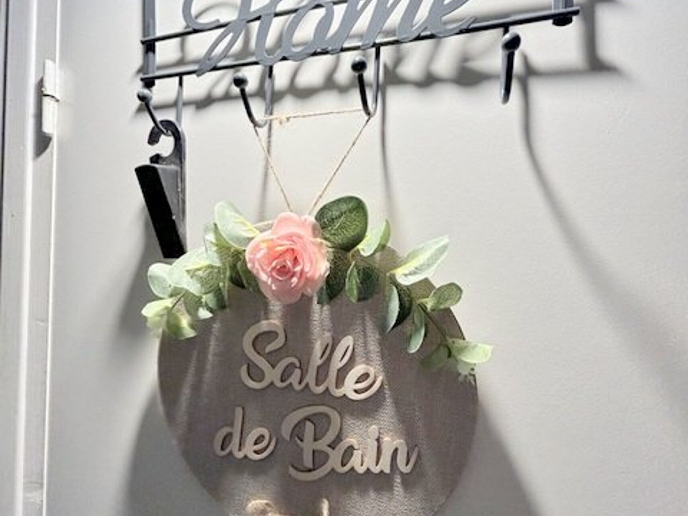 A sign with the text "Salle de Bain" hanging on a wall.