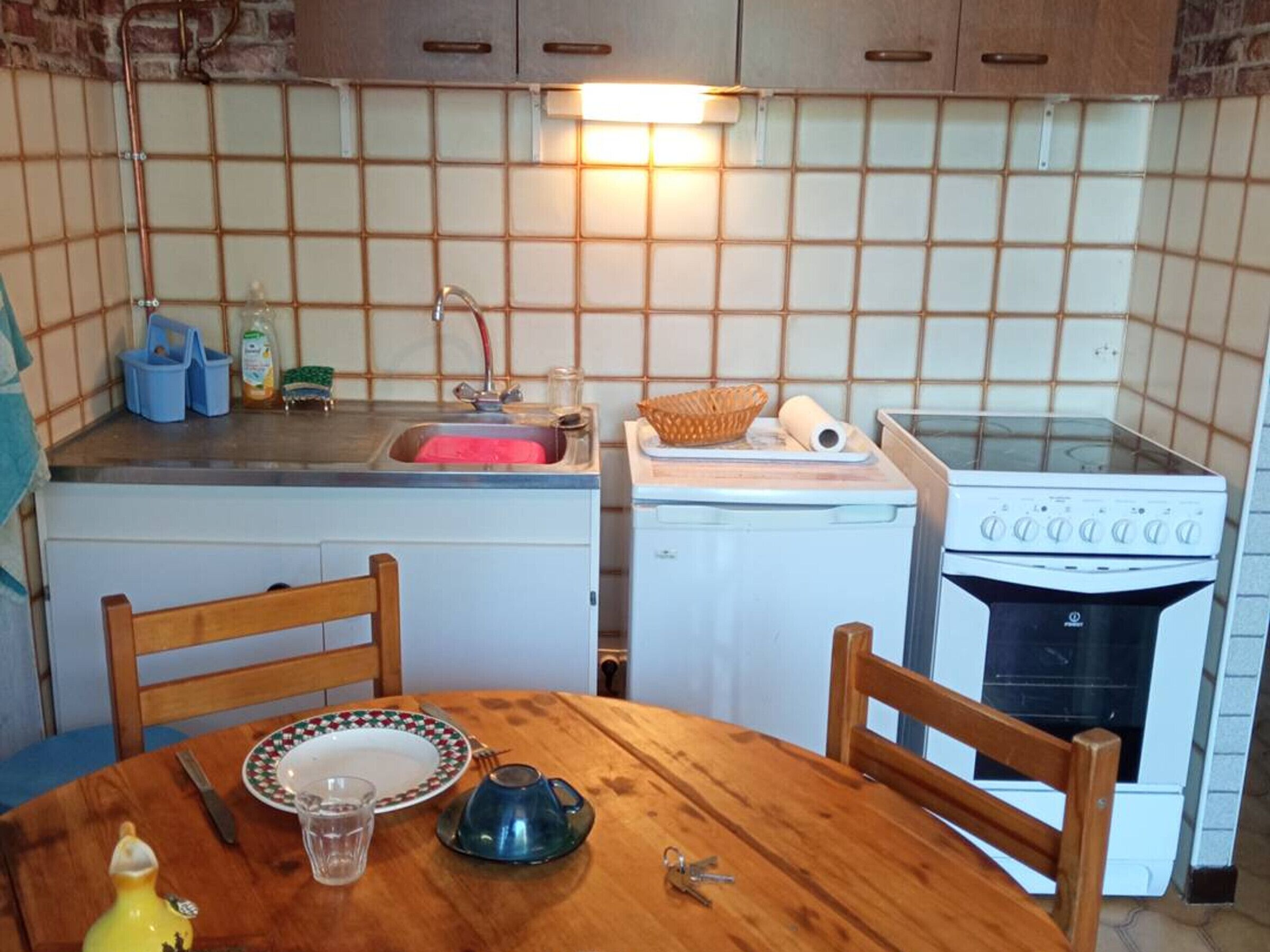 Cozinha com pia, fogão e mesa com cadeiras.