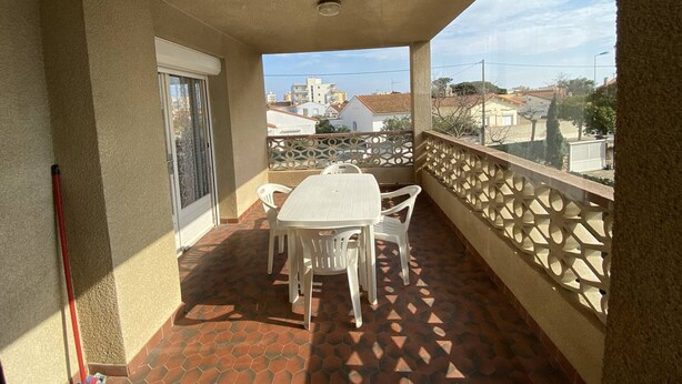 A balcony with a table and chairs, a view of buildings, and a patterned floor. - 3-room apartment with terrace and parking in Canet-Plage (Canet-Plage)