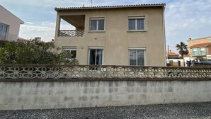 A two-story building with a balcony on the upper floor, a satellite dish on the roof, and a decorative fence in front. - 3-room apartment with terrace and parking in Canet-Plage (Canet-Plage)