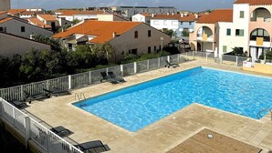 A rectangular swimming pool with a tiled deck, surrounded by a white fence. - Charming T2 with mezzanine and parking in Le Barcarès (Le Barcarès)