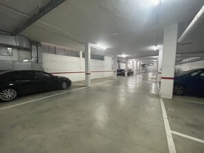 A multi-level parking garage with concrete floors and white walls. - Central Apartment in Roses, Close to Beach, Shops, and Bus Station (Roses)