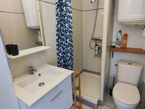 Ein Badezimmer mit Waschbecken, Toilette, Dusche und Spiegel.