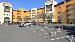 Un estacionamiento de varios pisos con una fila de autos estacionados y un cielo azul despejado.