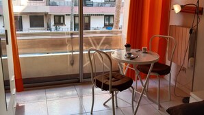 A balcony with a view of a building, a table with chairs, and a lamp. - Studio for 4 near the sea in Canet-en-Roussillon (Canet-en-Roussillon)