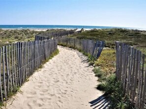 A sandy pathway bordered by wooden fences leading to a beach. - Studio for 4 near the sea in Canet-en-Roussillon (Canet-en-Roussillon)