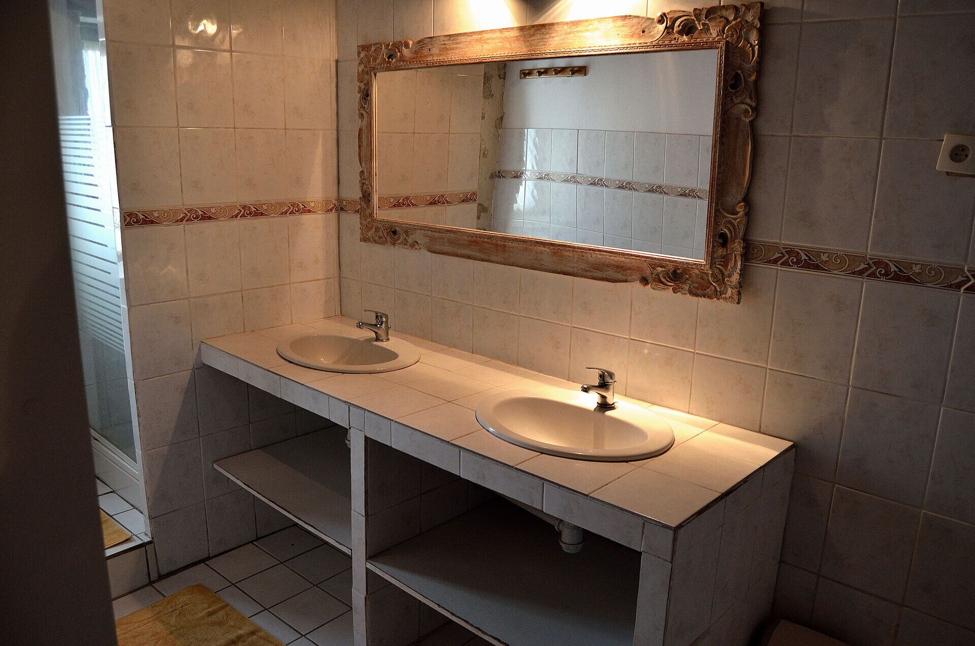 A bathroom with two sinks, a mirror, and a towel rack.