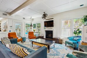 A spacious living room with a large sofa, two armchairs, a coffee table, and a fireplace. - Dog-friendly Cottage by the Beach With Private Pool, Pool Spa, & Free Wifi (St. Simons Island)