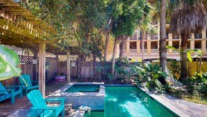 A pool area with lounge chairs, a wooden deck, and a covered seating area. - Dog-friendly Cottage by the Beach With Private Pool, Pool Spa, & Free Wifi (St. Simons Island)