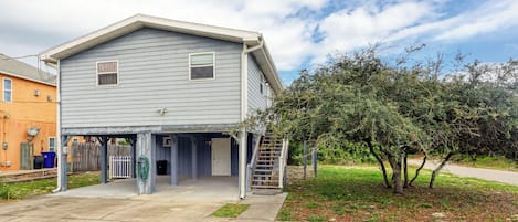 A two-story house with a covered front porch and a small staircase leading to the entrance.