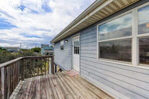Una terraza de madera con vistas a una casa y los alrededores.