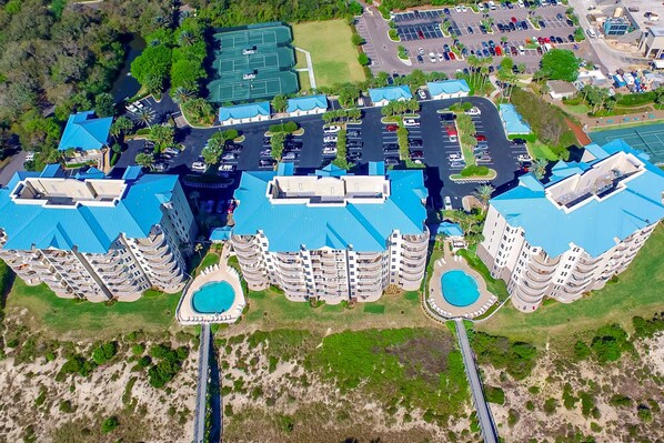 Un hôtel de grande hauteur doté de nombreux balcons, d’une piscine et d’un parking.