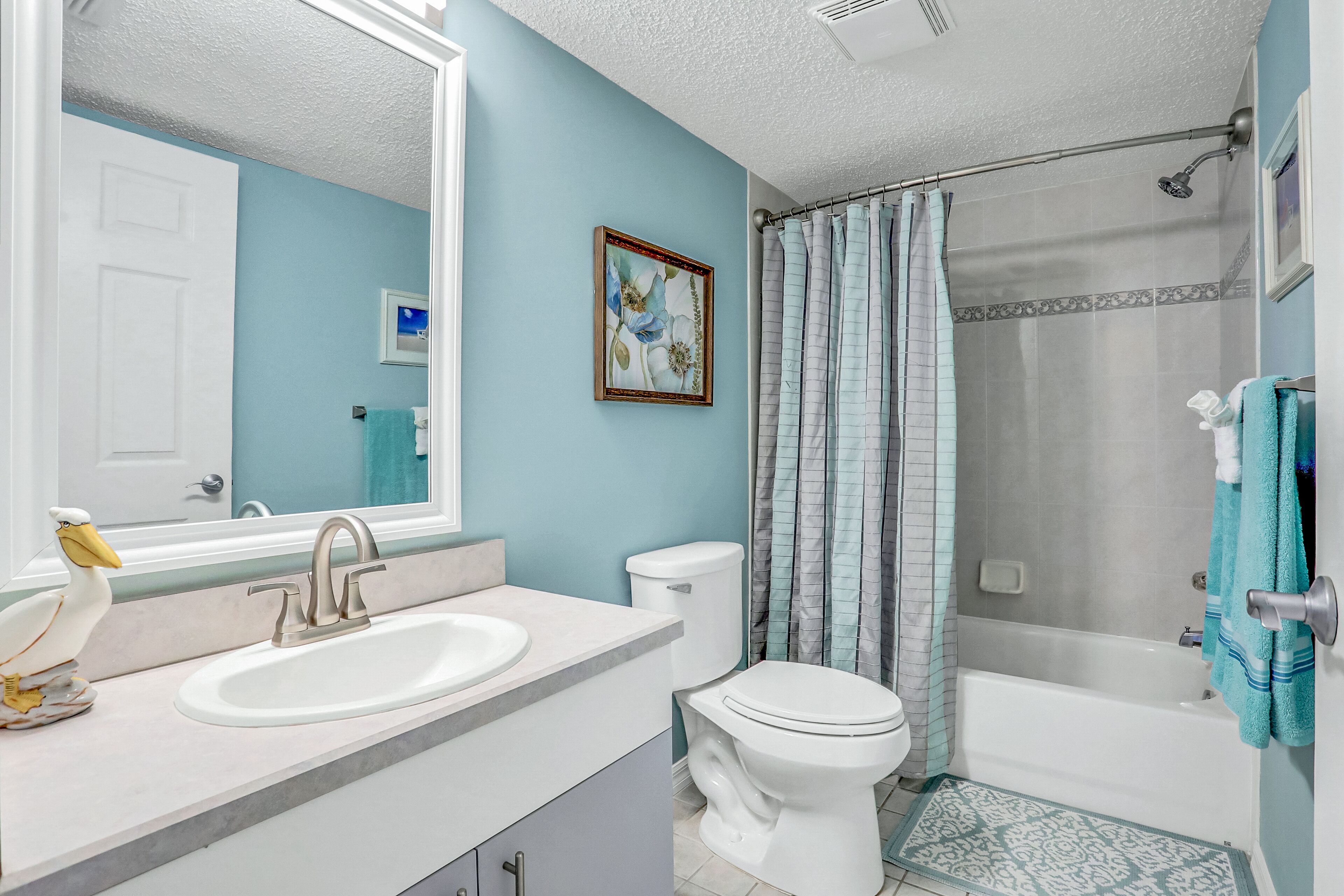 A bathroom with a sink, toilet, and bathtub.