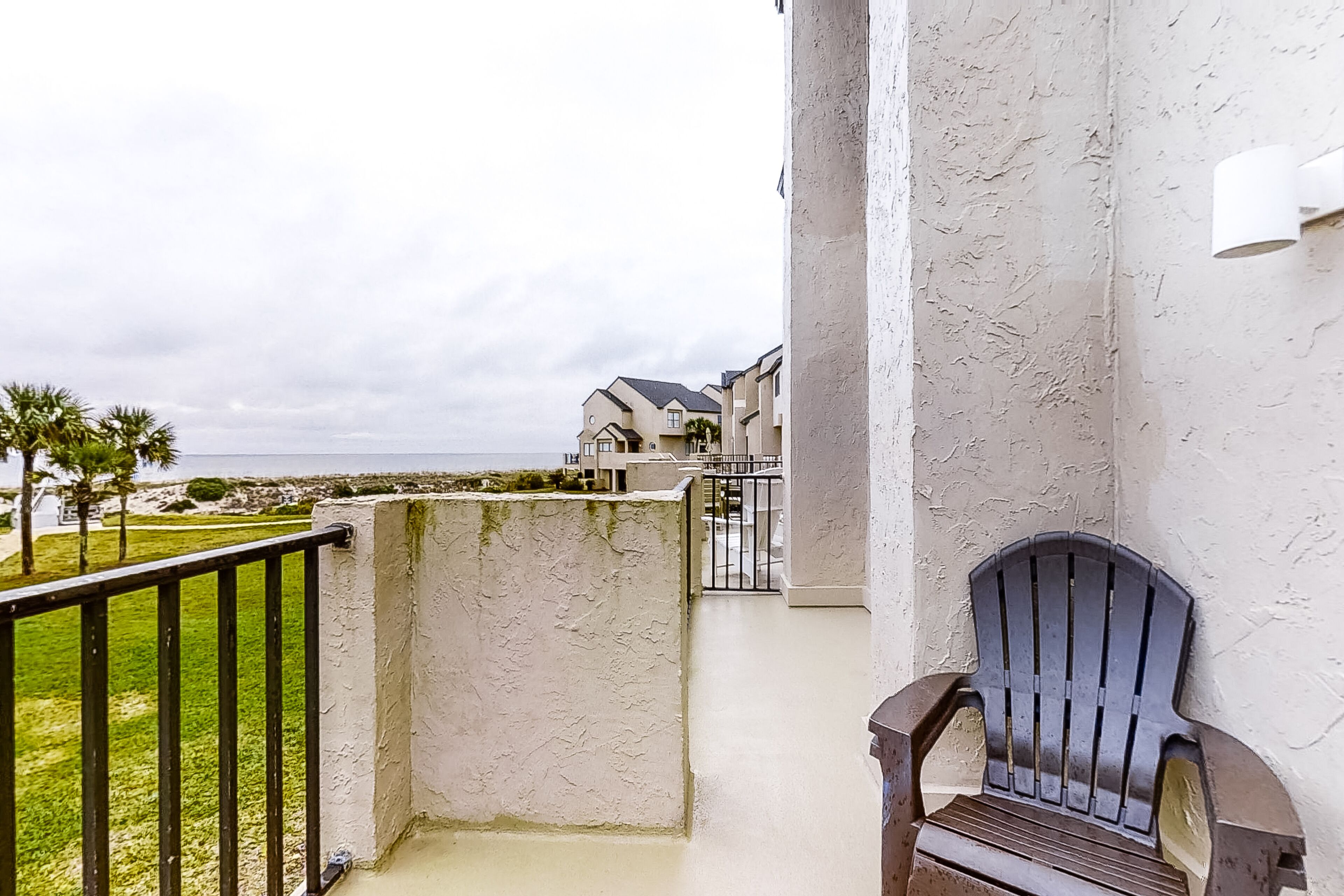 Een balkon met uitzicht op een woongebied en een waterpartij.