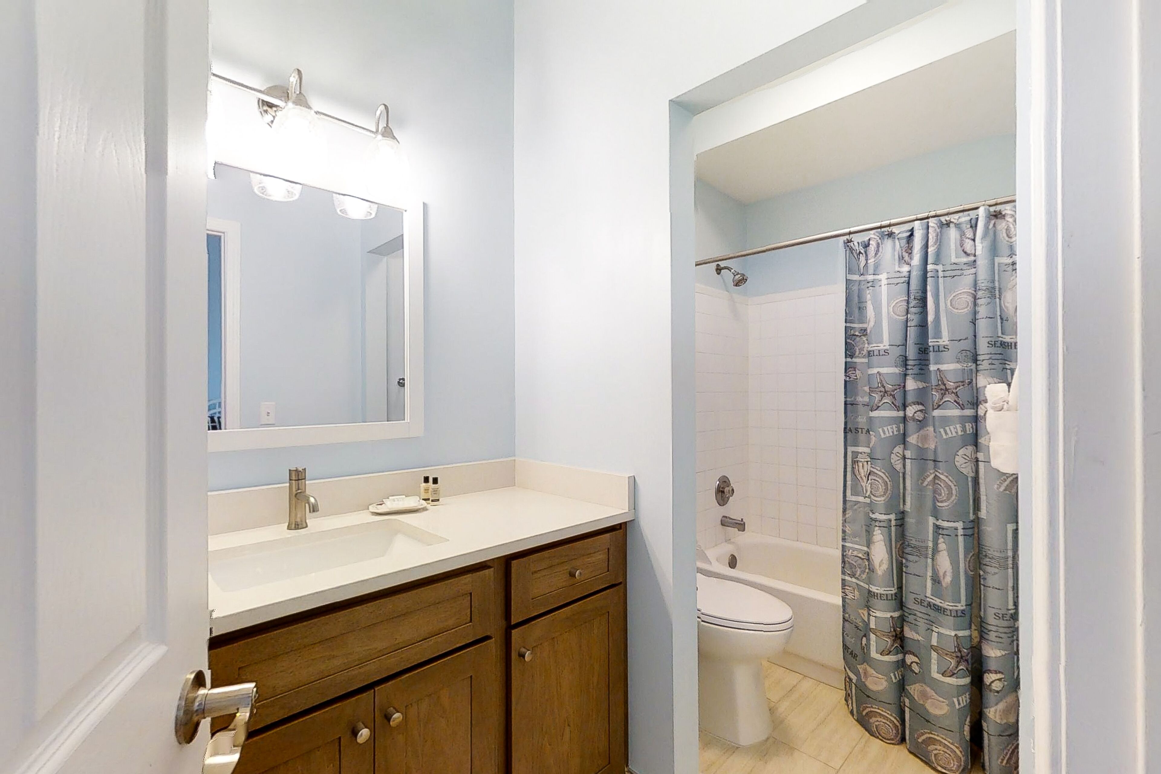 A bathroom with a sink, mirror, and toilet.