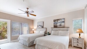 A bedroom with two beds, a ceiling fan, and artwork on the walls. - Dog-friendly Tennis Villa Suite in Amelia Island W/shared Pool, Free Wifi (Fernandina Beach)