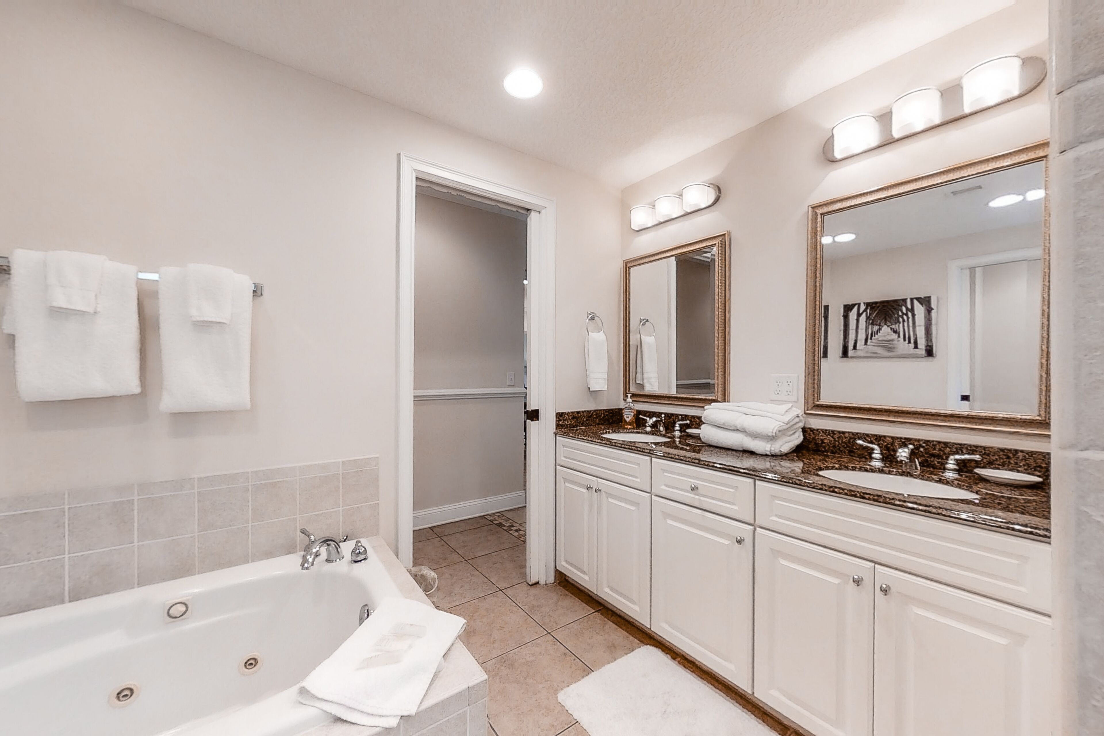 Une salle de bain moderne avec une baignoire, deux lavabos et un grand miroir.