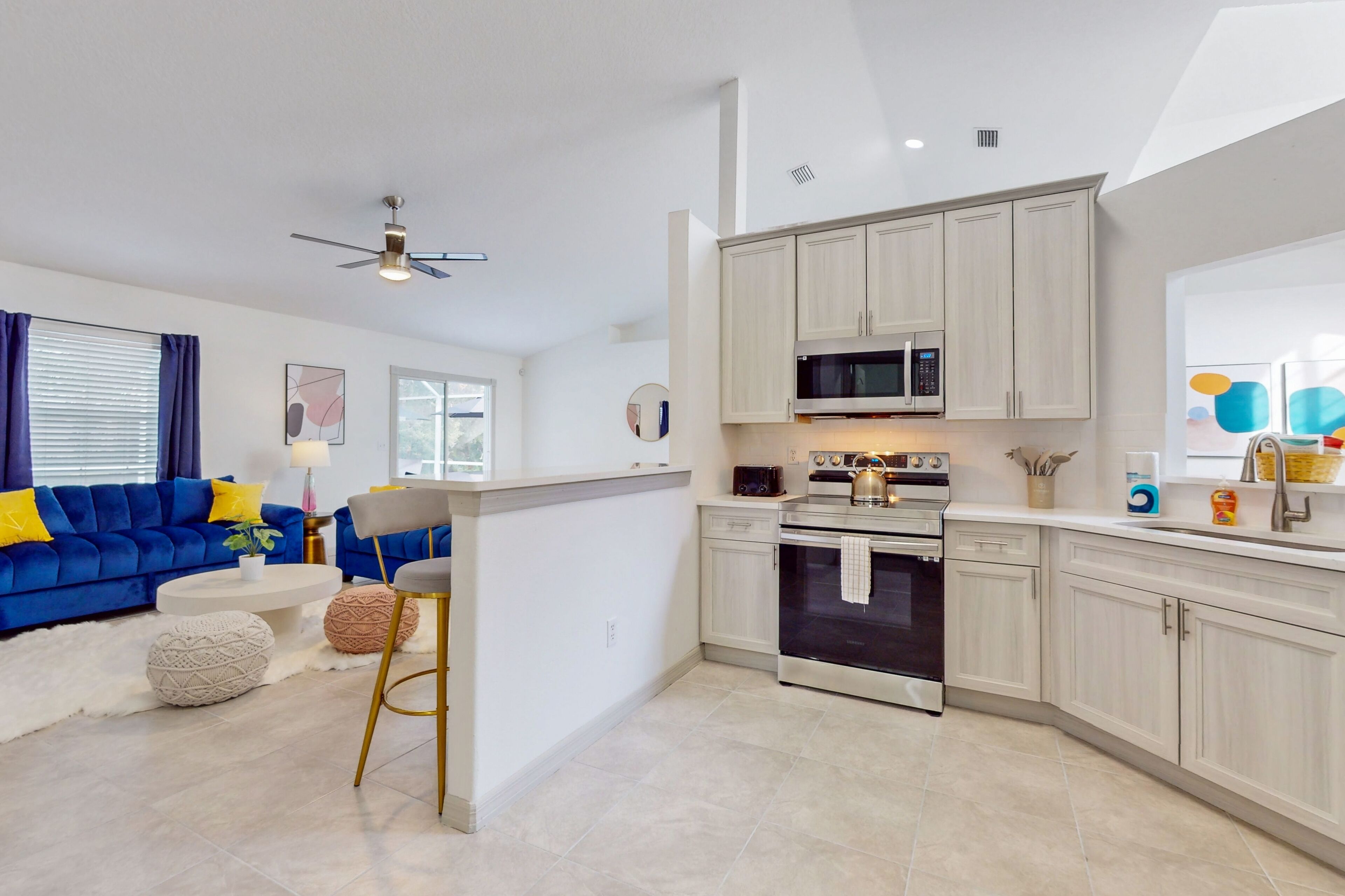 A modern kitchen with white cabinets, stainless steel appliances, and a central island.