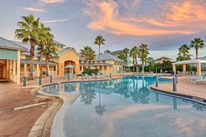 A resort with a large pool, palm trees, and a building with a curved roof. - Luxurious Beach Villa Steps to Cinnamon Beach! Ocean and Lake Views (Palm Coast)