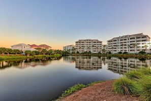 A hotel with multiple buildings, a calm lake, and surrounding greenery. - Luxurious Beach Villa Steps to Cinnamon Beach! Ocean and Lake Views (Palm Coast)