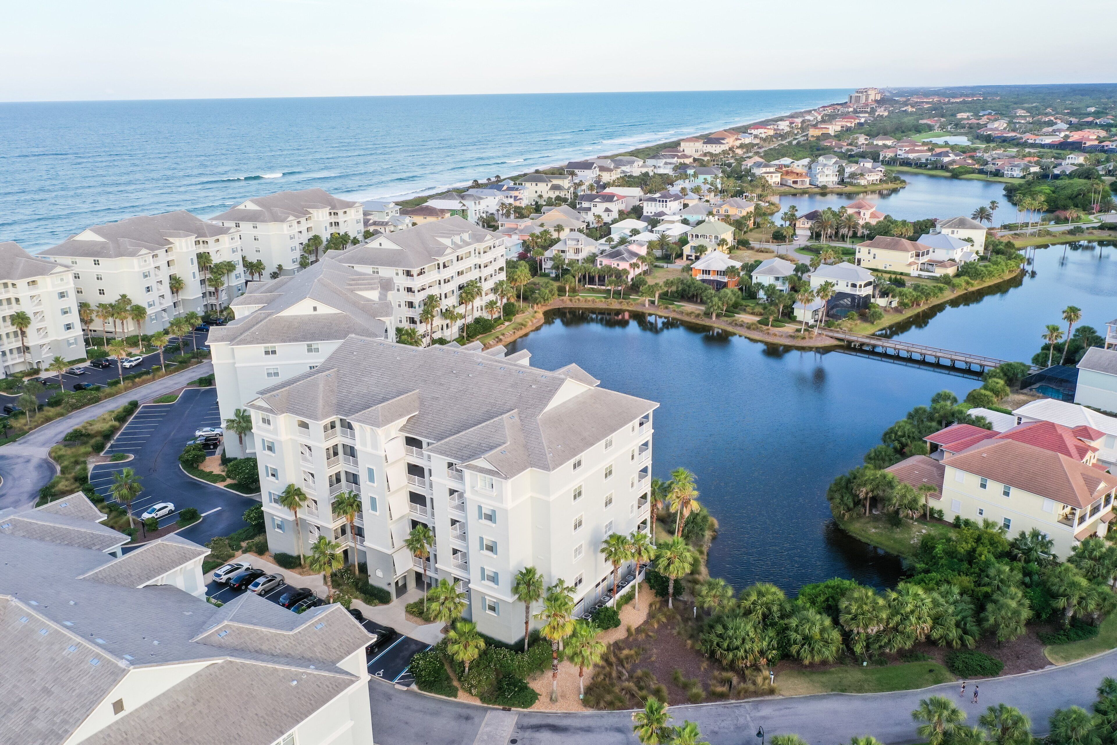 A coastal residential area with multi-story buildings, a marina, and a bridge.