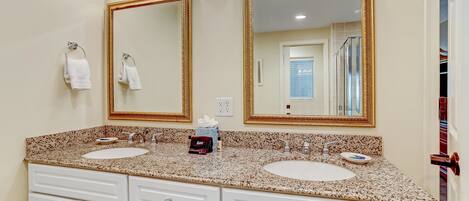 A bathroom with two sinks, a large mirror, and a vanity with drawers.