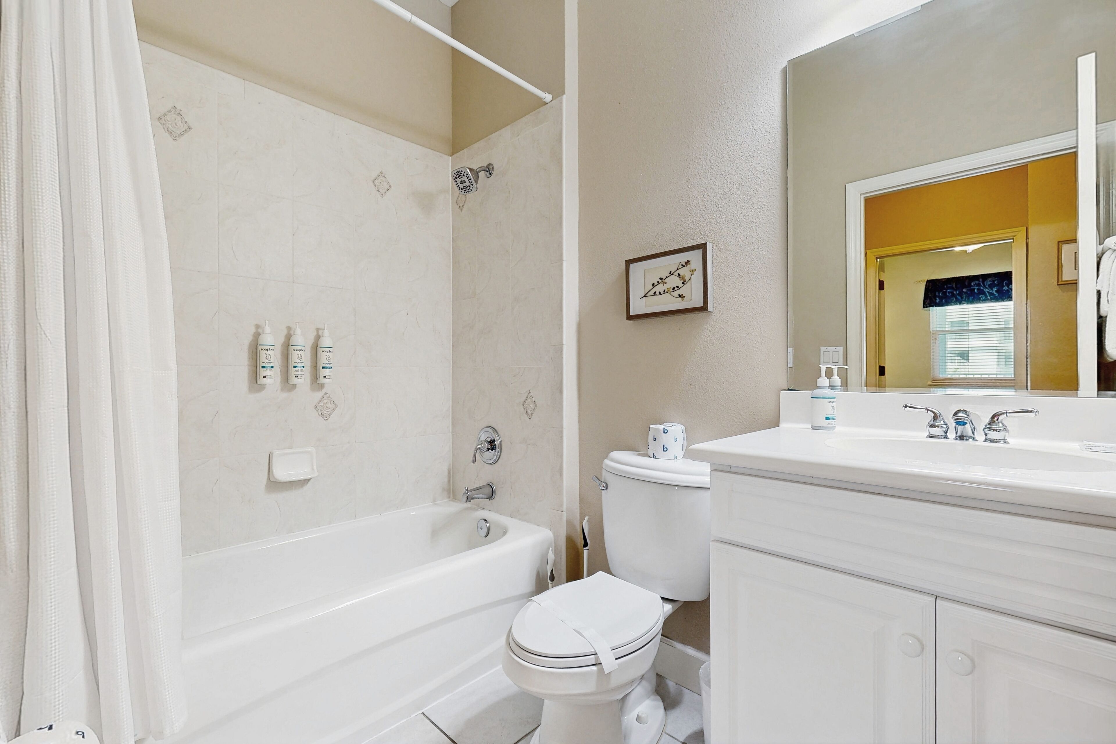 Een badkamer met bad, toilet en wastafel.