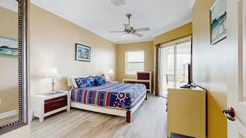 A bedroom with a bed, nightstands, a dresser, a ceiling fan, and a door leading to another room.