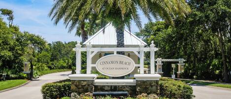A gated entrance with a sign reading 'CINNAMON BEACH AT OCEAN HAMMOCK'.