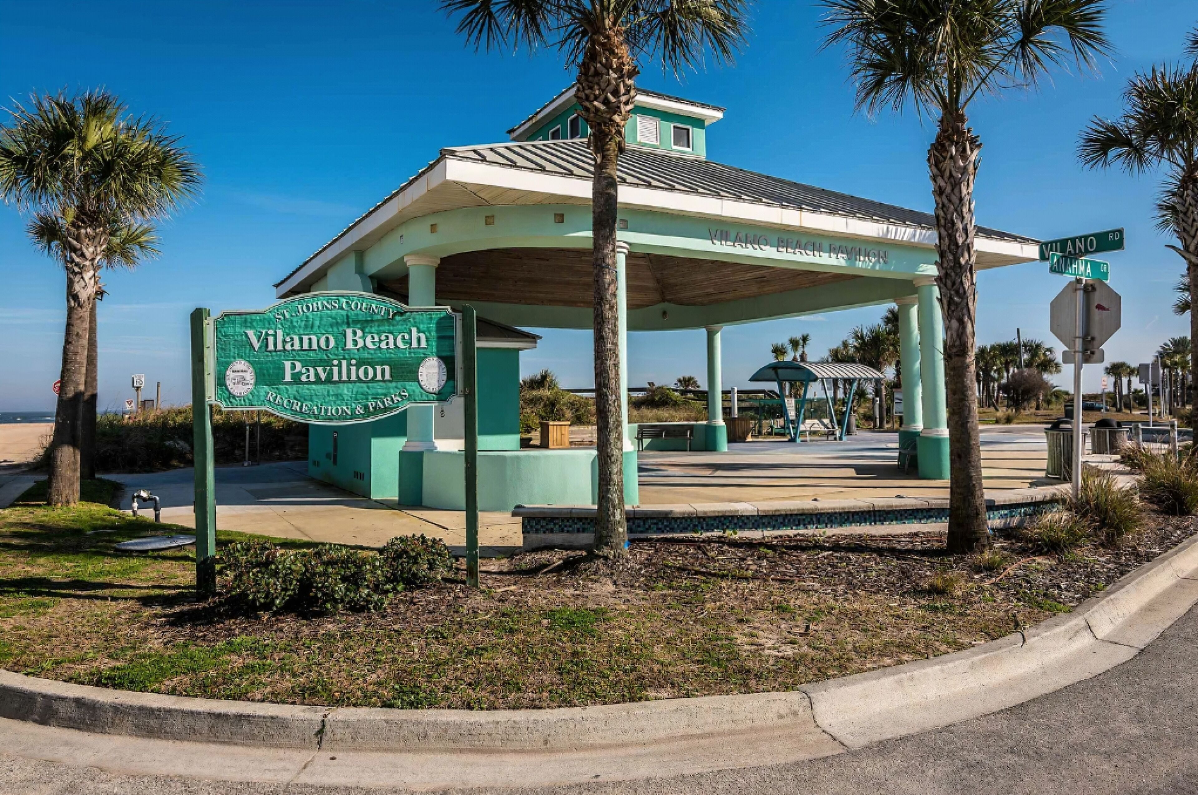 Un pabellón verde con un letrero que dice "Vilano Beach Pavilion" y "St. Johns County Recreation & Park".
