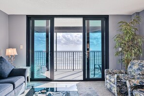 Een woonkamer met balkon, een bank, een salontafel en een lamp.