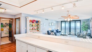 Eine moderne Küche mit weißer Arbeitsplatte, Holzschränken und einem Deckenventilator.