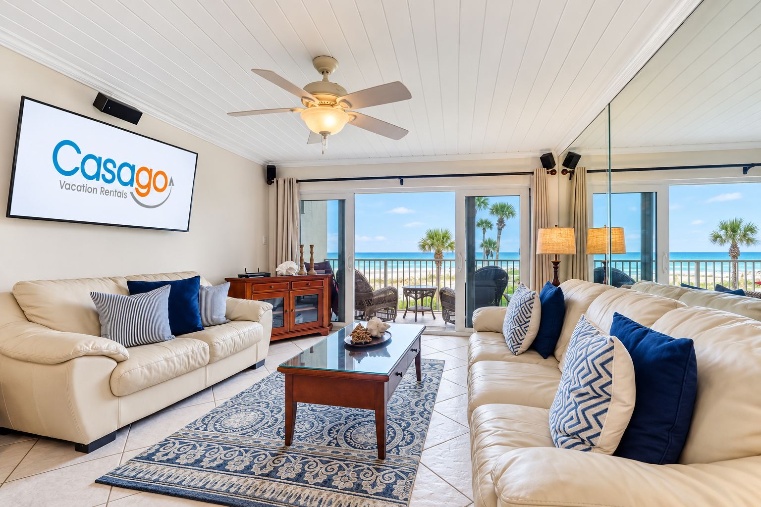A spacious living room with a large sofa, a coffee table, and a television displaying 'Casago Vacation Rentals'.