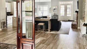 A spacious kitchen with wooden flooring, a central island, and a dining area. - Golf Course-view Home Near Beaches With Deck, Porch, Grill, Streaming, W/d, & AC (St. Simons Island)