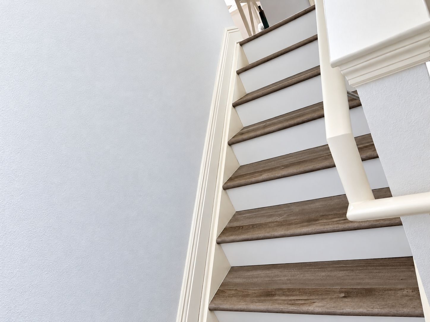 A staircase with wooden steps and white handrails.