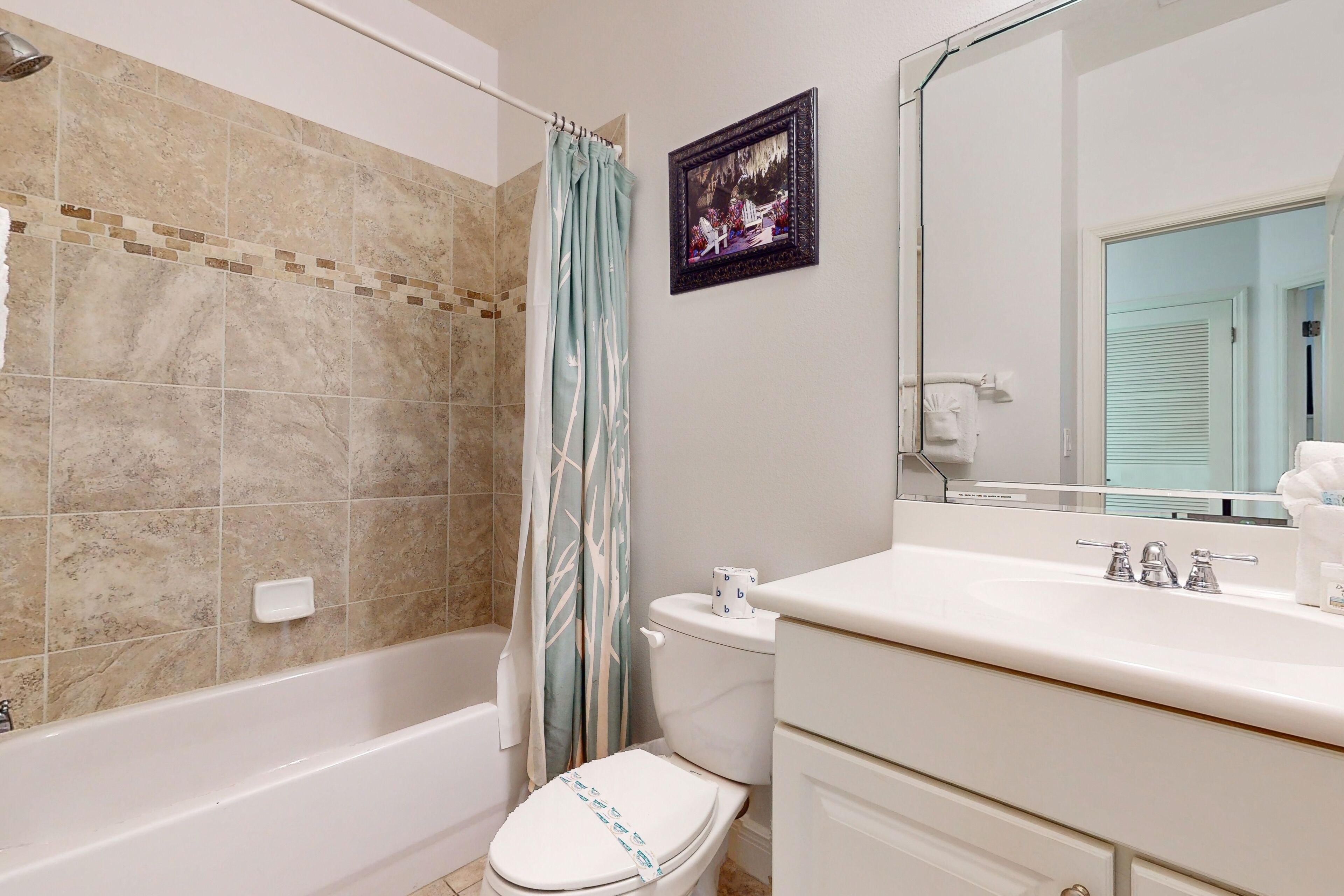 A bathroom with a bathtub, toilet, and sink.