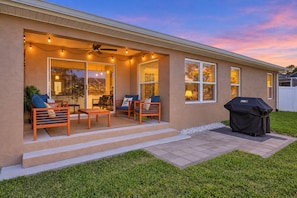 A residential exterior with a covered patio, outdoor seating, and a barbecue grill. - Dog-friendly Home With an 8 Minute Walk to Beach Access (Palm Coast)